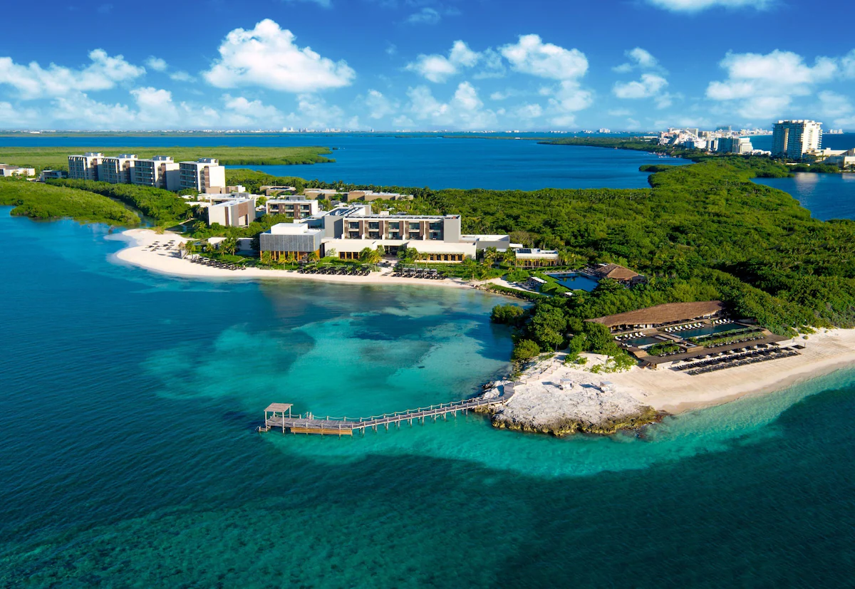 Oceanfront infinity pool at Nizuc Resort and Spa, framed by tropical palms and serene turquoise waters