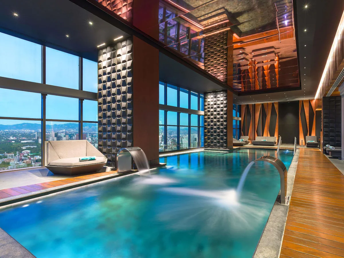 Elegant guest room at Sofitel Mexico City Reforma featuring modern décor, panoramic city views, and ambient lighting.
