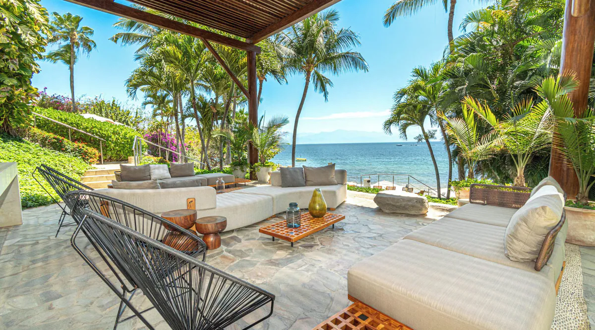Oceanfront balcony view at Arena Blanca 408, showcasing tranquil waves and golden sunset over La Cruz de Huanacaxtle.