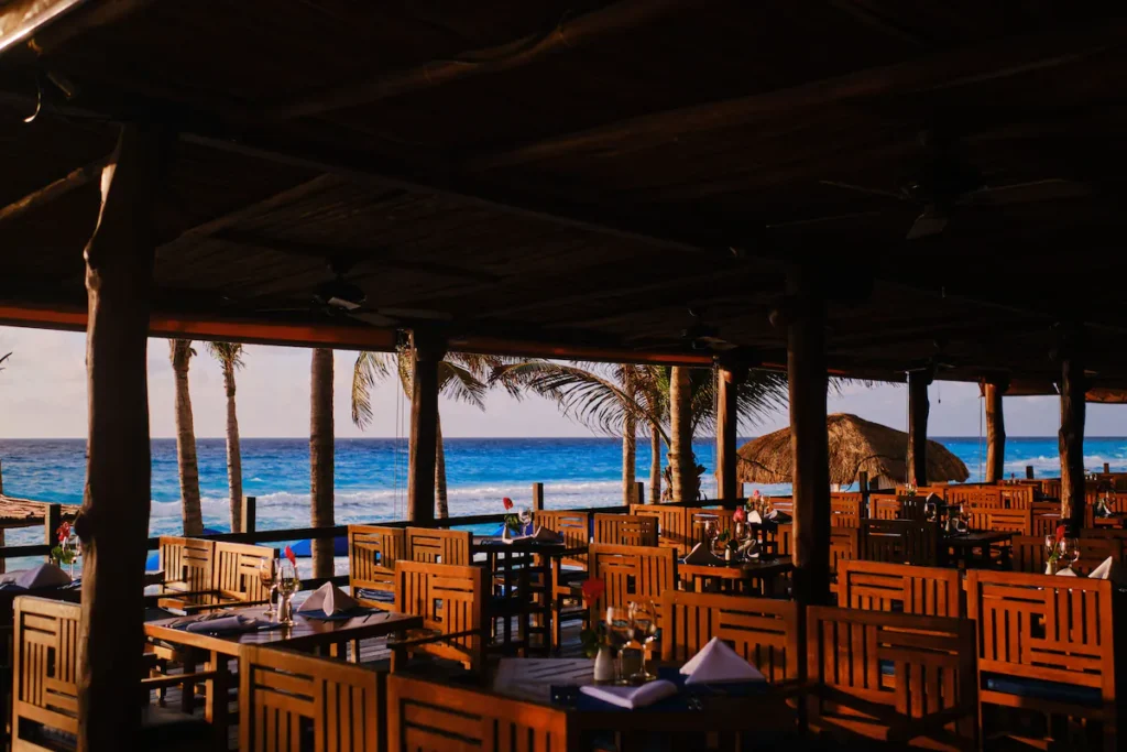 Modern beachfront hotel with infinity pool overlooking turquoise Caribbean waters near La Isla Shopping Mall in Cancun.