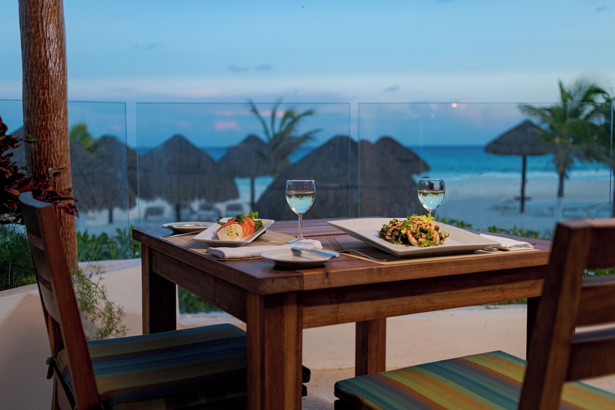 Beachfront view of Krystal Cancun hotel with turquoise waters and palm trees