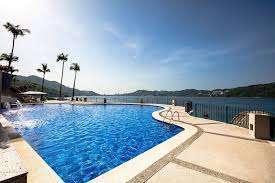 Luxury cliffside resort in Acapulco with direct water access, sunset lighting, and panoramic bay views.