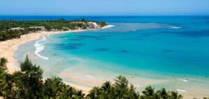 Wide sandy shoreline at Playa Azul Beach with gentle surf, artisanal fishing boats, and coastal wetlands near Cuajinicuilapa